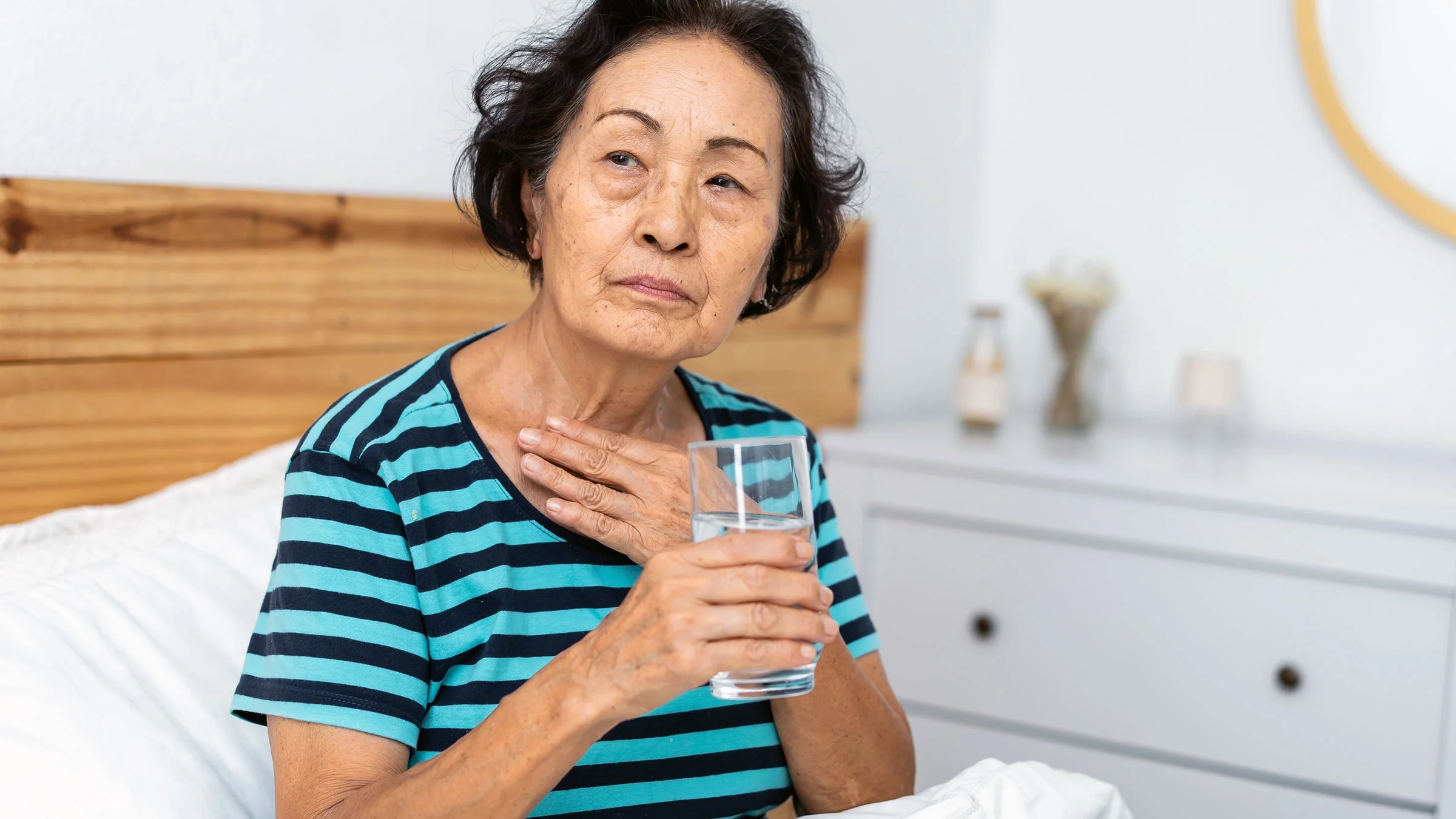 Woman with sore throat drinking water
