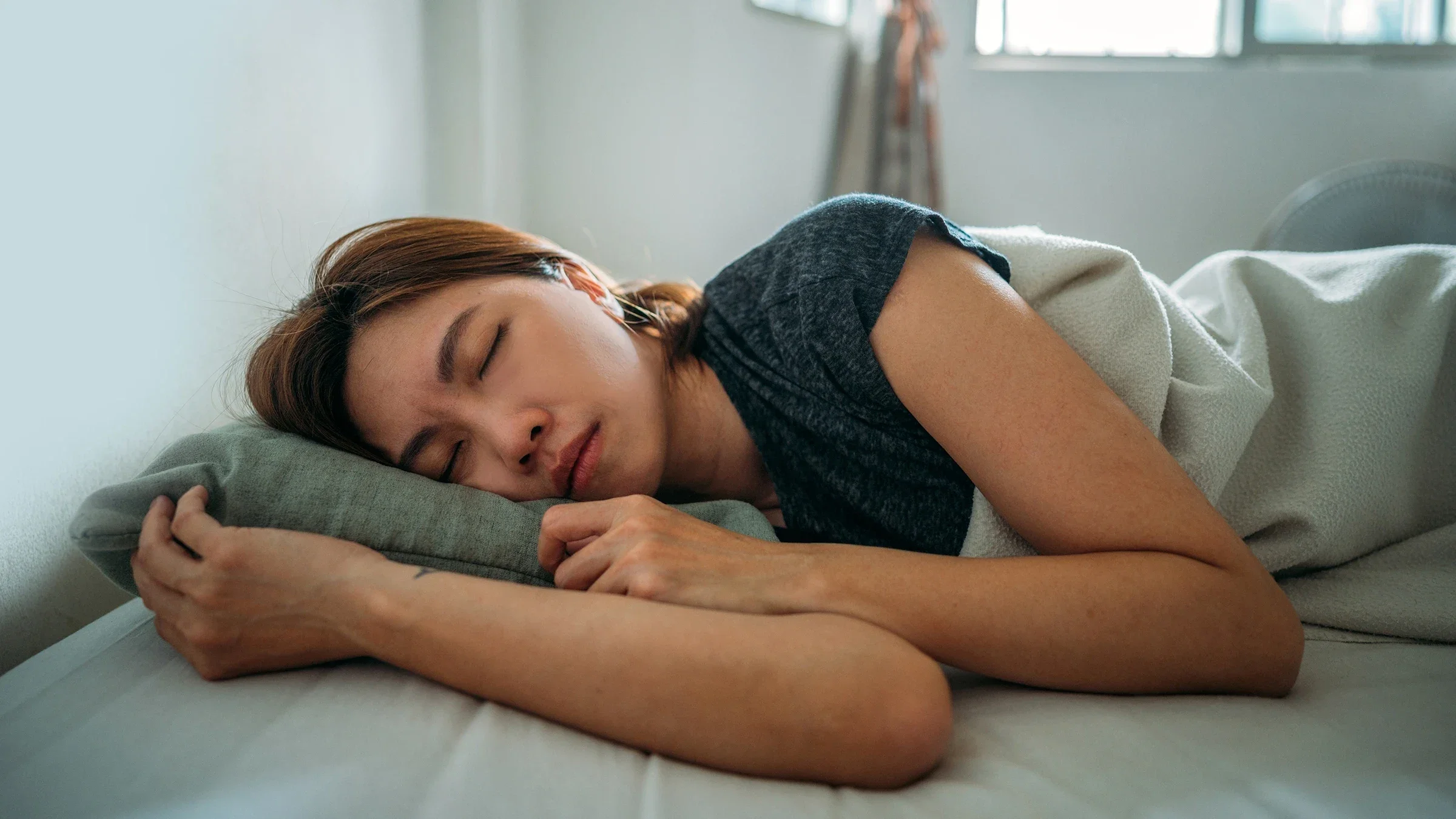 A woman is sleeping on her side in bed.
simon2579/E+ via Getty Images 