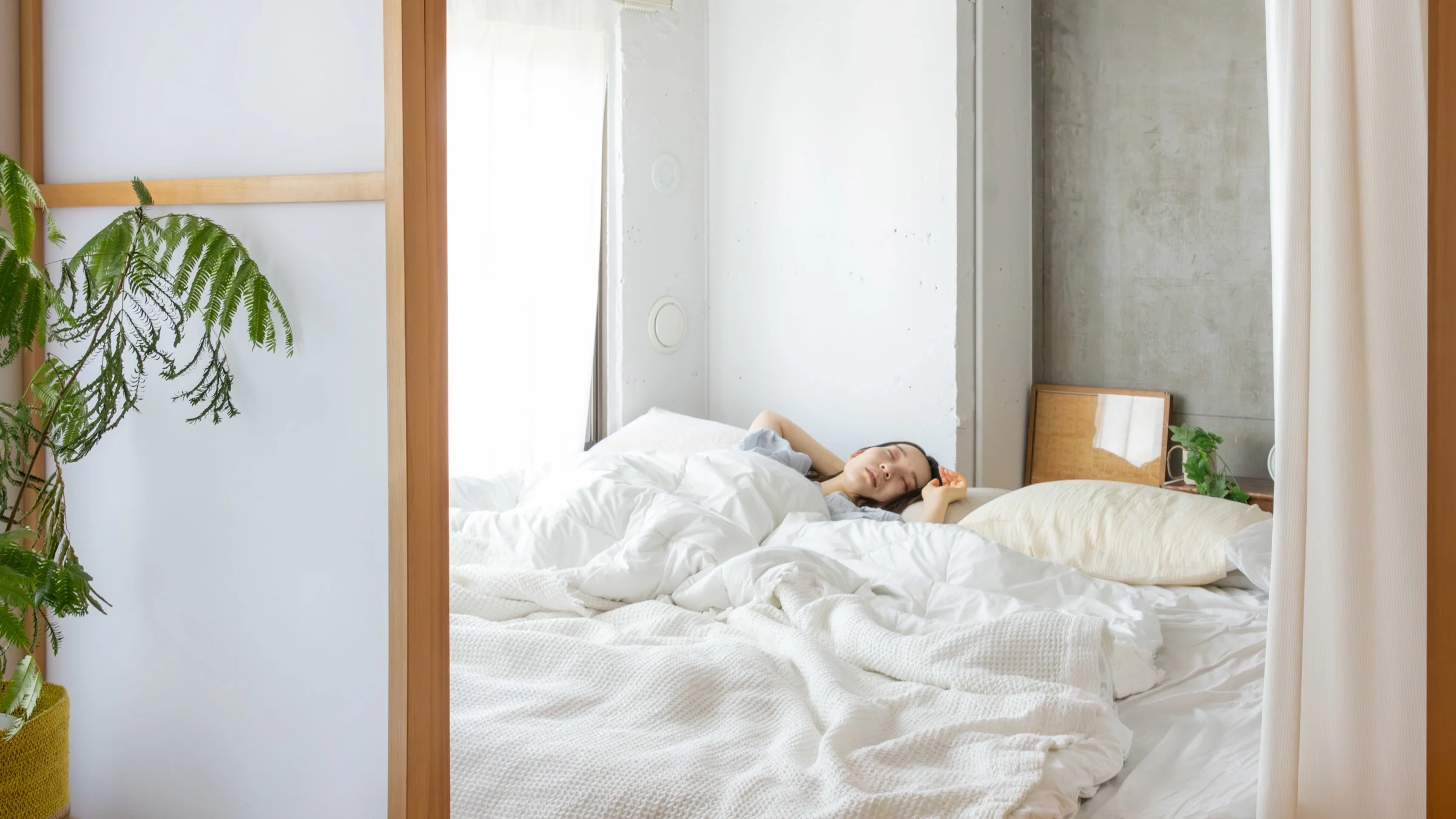 A person sleeping in bed in the daytime.