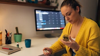 cannabis: woman holds jar of cannabis buds 1451739048