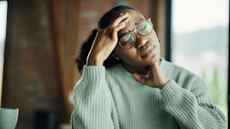 A woman is holding her head in pain like she has a migraine.
skynesher/E+ via Getty Images   