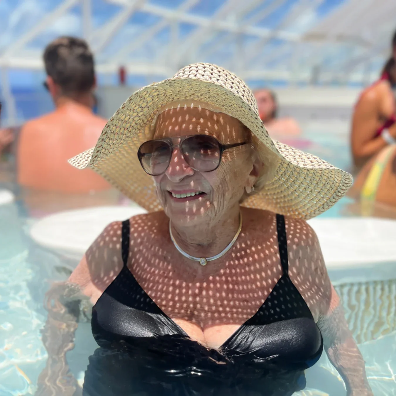 Mildred Kirschenbaum is pictured wearing sunglasses and a sun hat at the pool.