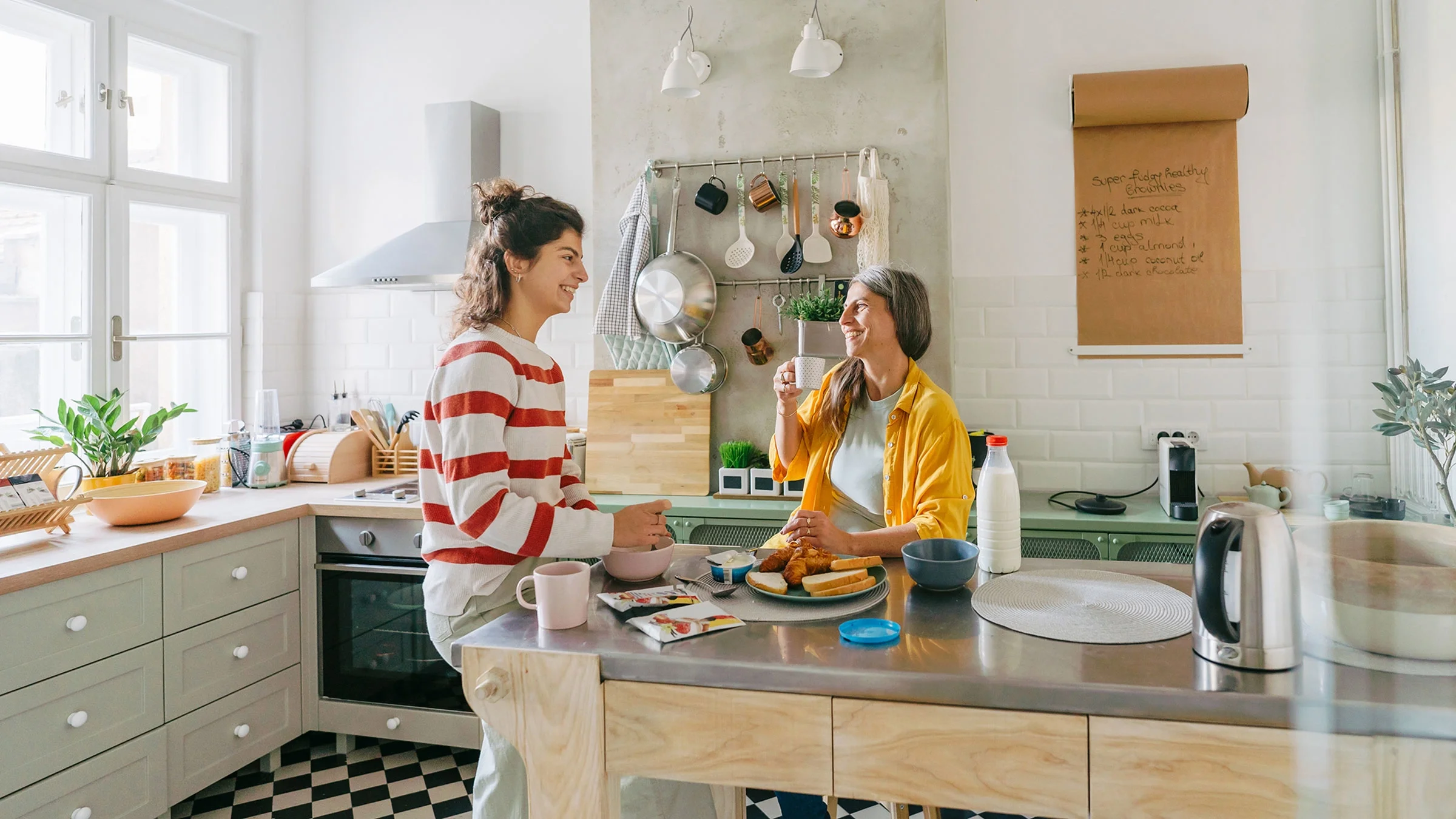 A woman has breakfast with her daughter in the kitchen. When taking pantoprazole, a medication to treat acid reflux, there are certain foods to avoid, such as greasy and spicy foods.