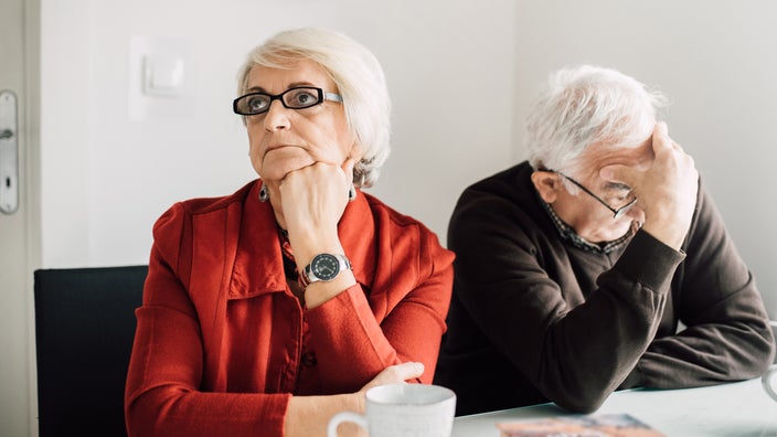 Senior couple in distress over paperwork and finances.