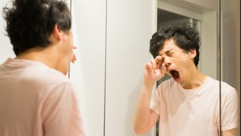 Health: Melatonin: tired man looking in mirror-1221636590