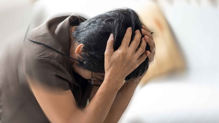 Woman with hands on her head feeling dizziness or vertigo