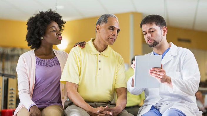 Man and daughter discuss treatment plan with a doctor.