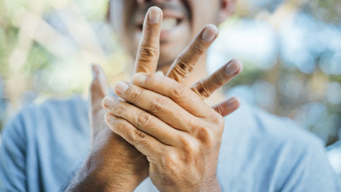Close-up of a man’s hands as he is rubbing them. 