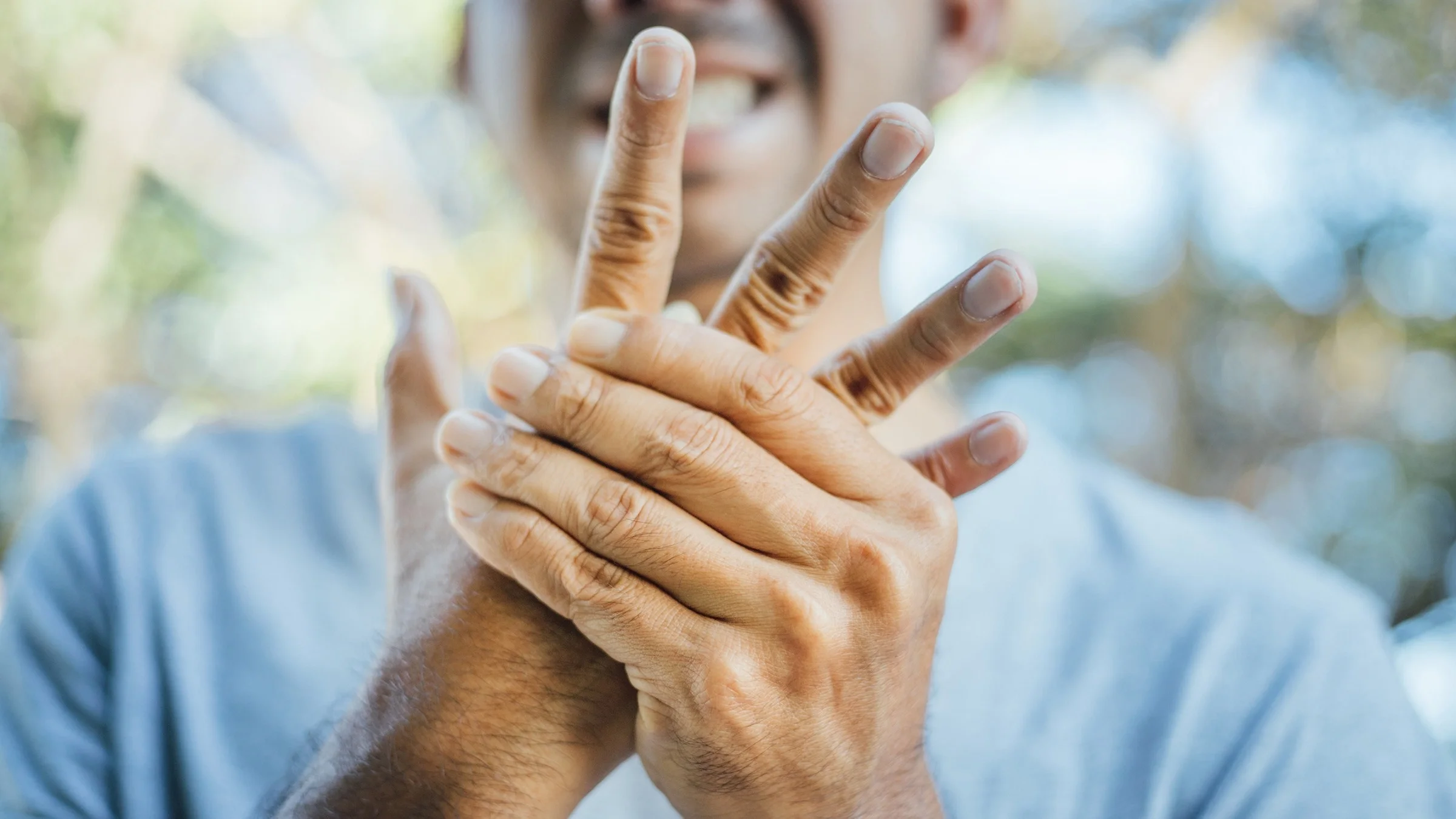Close-up of a man’s hands as he is rubbing them.