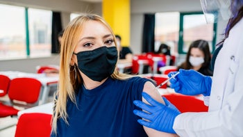 Research: Vaccines or natural infection COVID: student getting vax in classroom 1310738295