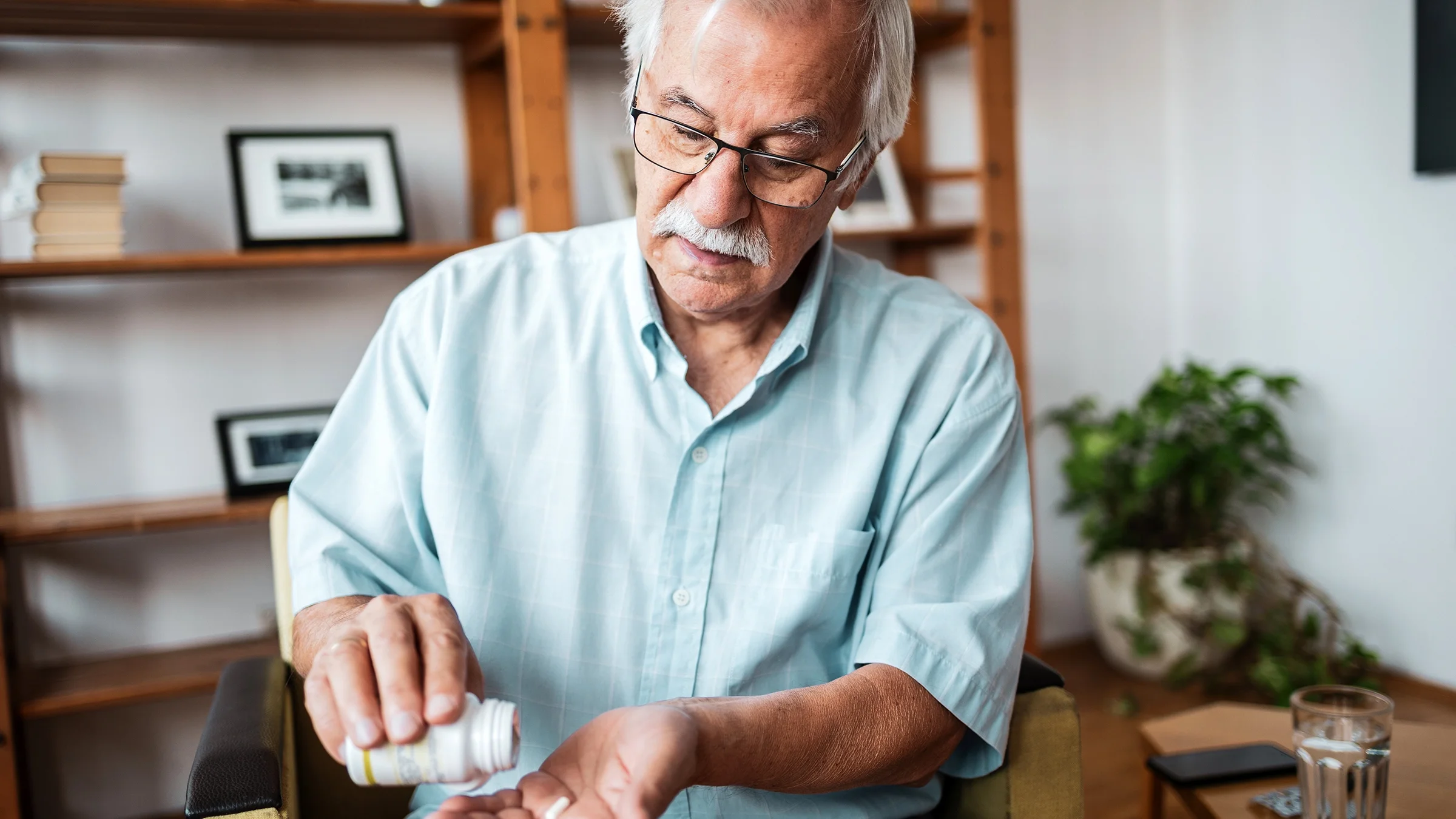 An older man takes medication.