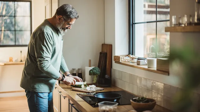 Colorectal-cancer: man prepping food in the kitchen 2033626512