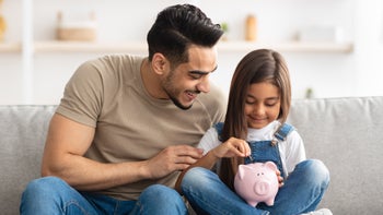 child and parent with piggy bank 1322976822