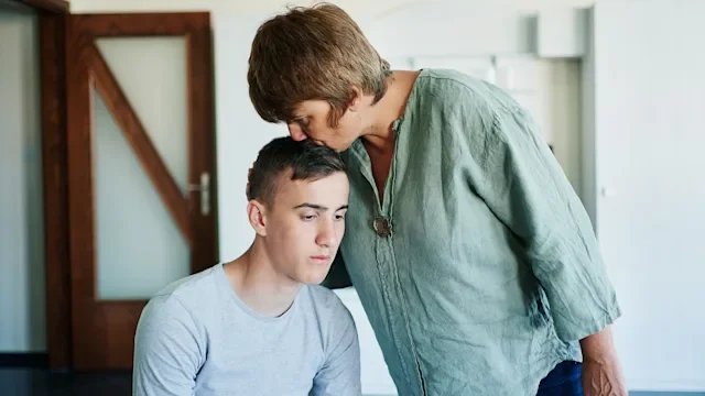 substance-use-disorder: mother supporting son kissing head-1335189503