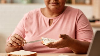 Dental care: woman spreading butter on toast 1460038583