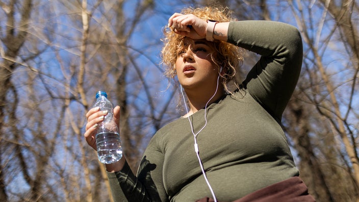 A woman takes a walk in the outdoors. Several factors contribute to maintaining weight loss, such as physical activity and diet. 