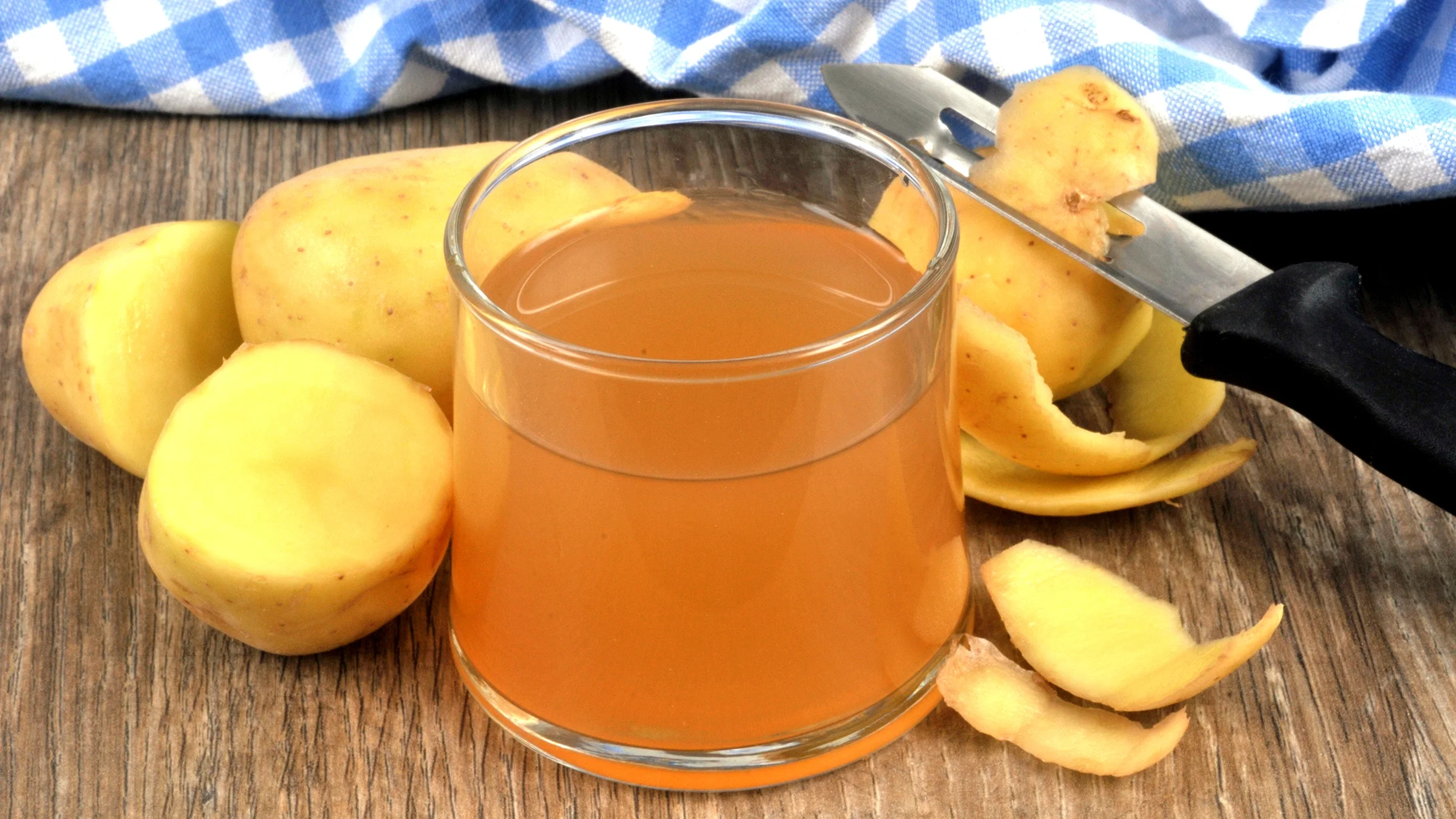 Shown is a glass of potato juice with its ingredient.