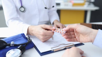 Lithium: doctor handing blister pack to patient 1300316334