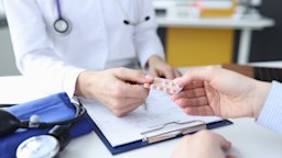 A doctor's hands giving a blister pack to a patient.
megaflopp/iStock via Getty Images Plus 