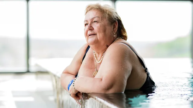 medicare: senior woman in swimming pool 1316936622