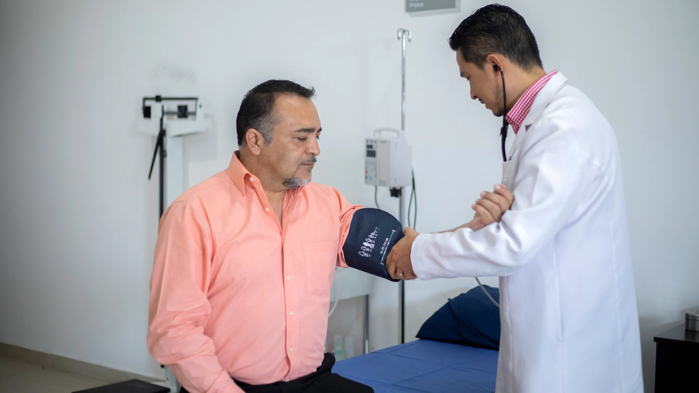 A healthcare professional measures a man’s blood pressure.