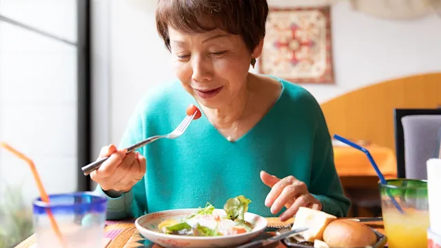 Health: Diet and nutrition: senior woman eating lunch at restaurant 1153358772
