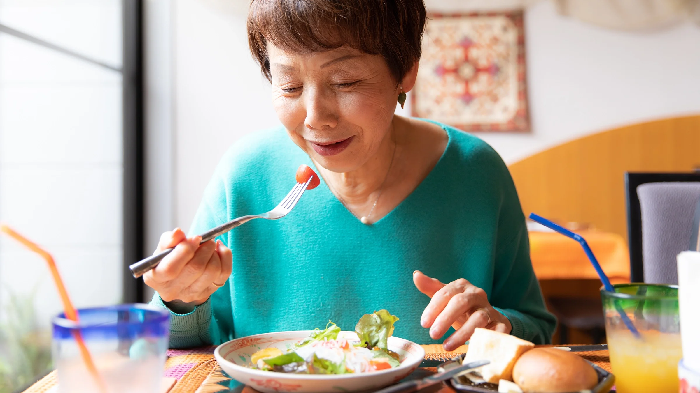 Senior woman eating a health salad at a restaurant. 