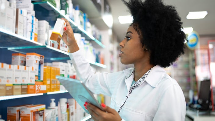 Pharmacist doing inventory. The photo is from the side profile view.