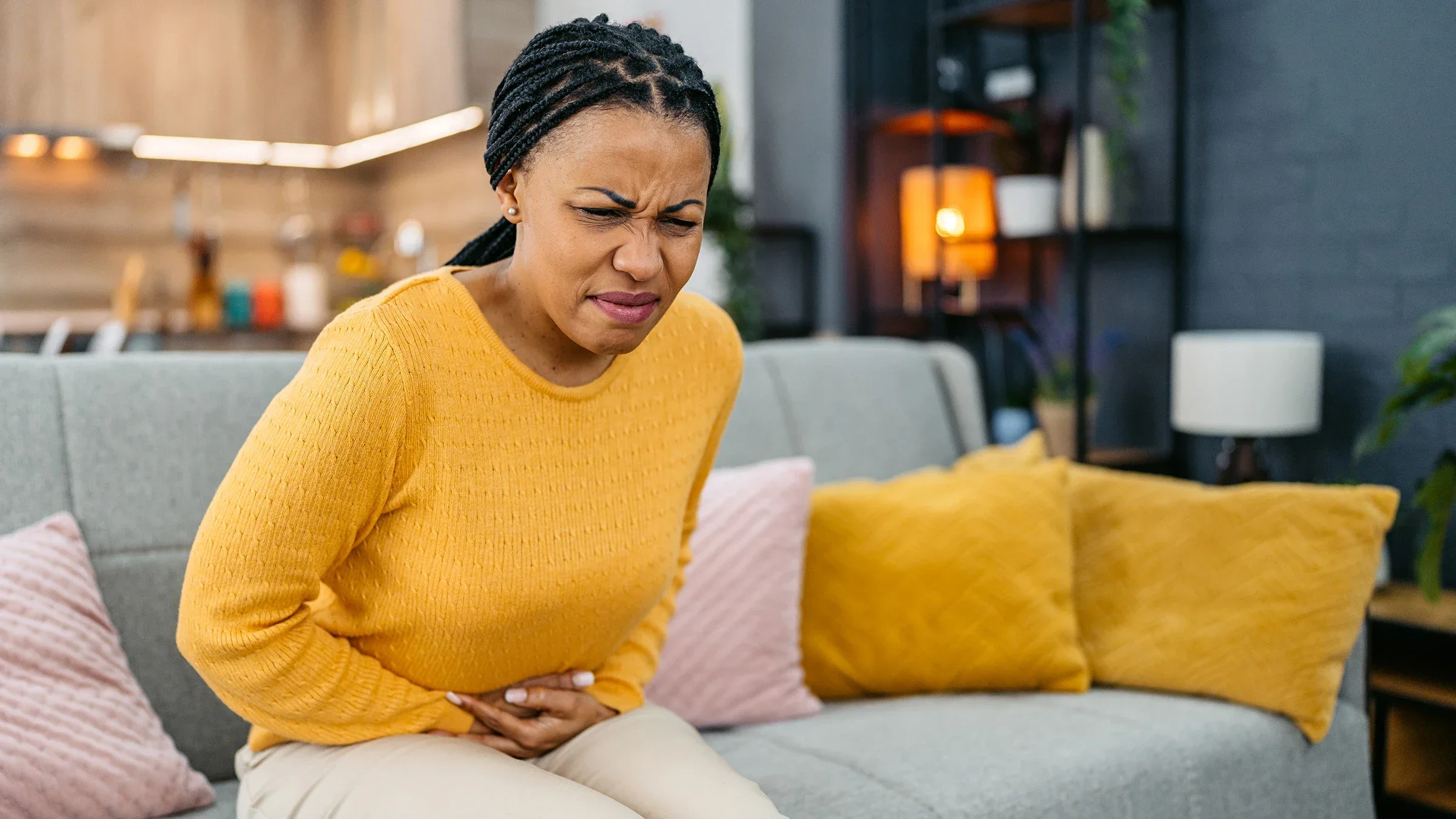A woman holds her belly as she experiences a stomachache.
urbazon/E+ via Getty Images