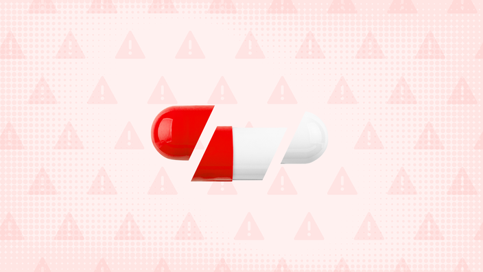 In the center of a light red background with texture and warning sign pattern is a white and red capsule pill cut into thirds. 