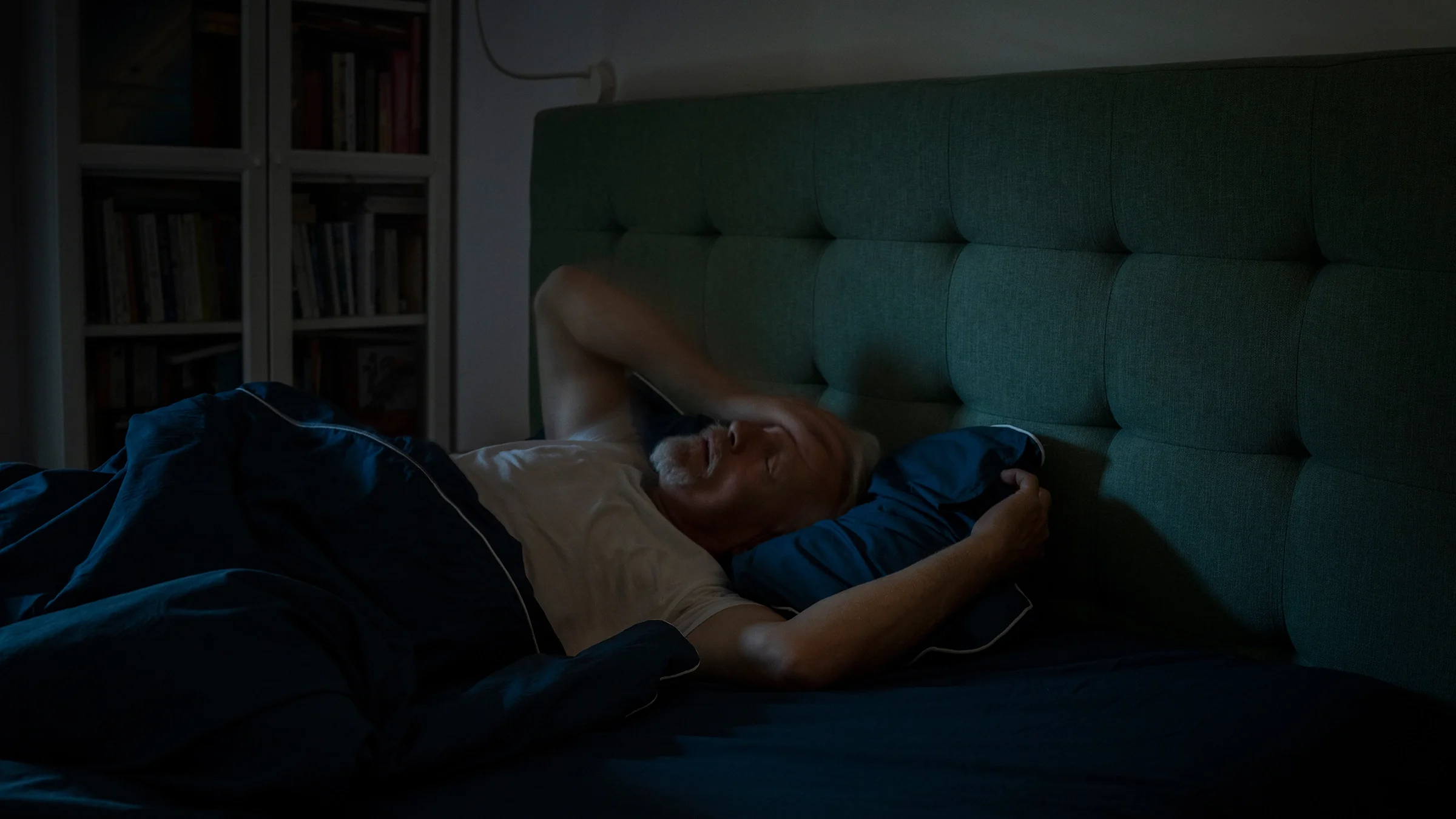 Man laying in bed trying to fall asleep