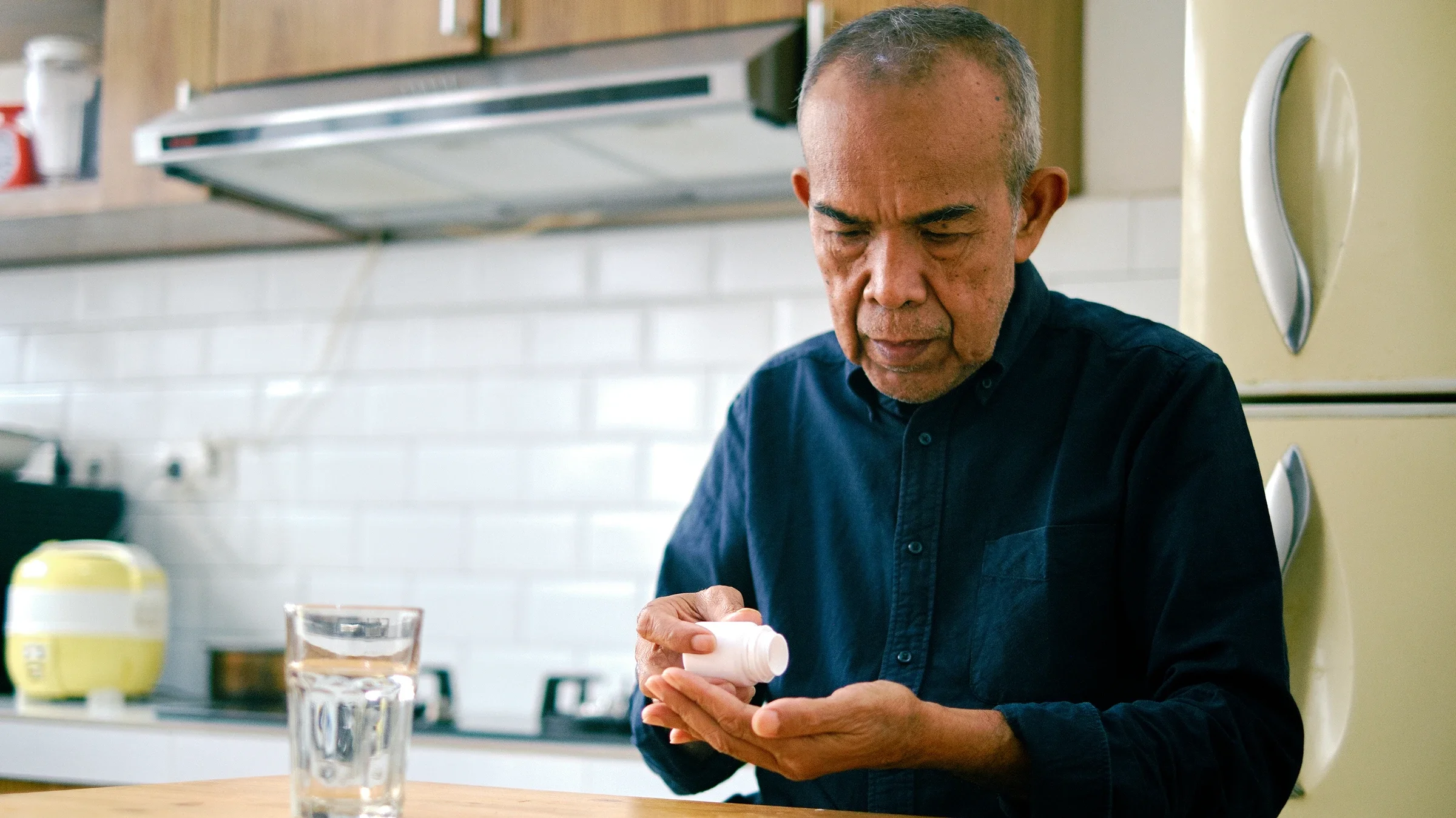 A man takes his medication at home.