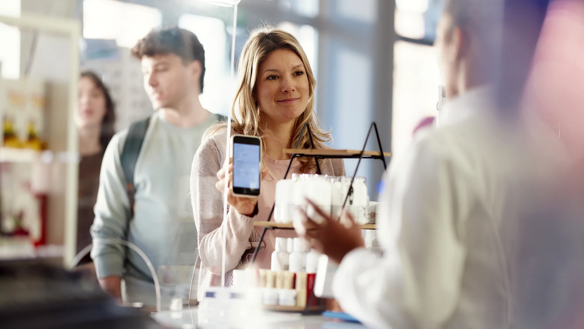A woman uses a mobile phone at the pharmacy.