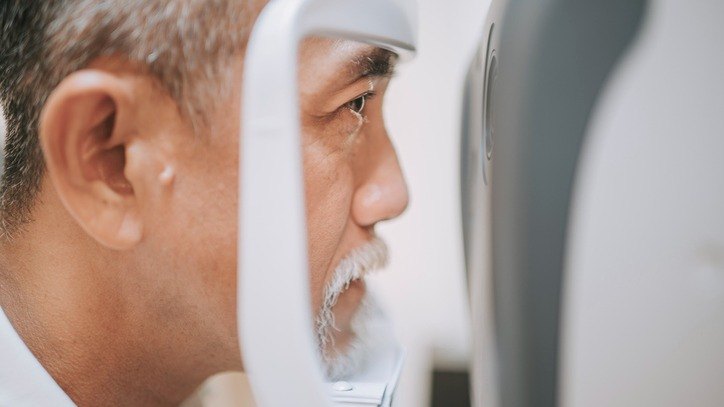 Close-up of an older man getting his eyes checked at the optometrist.