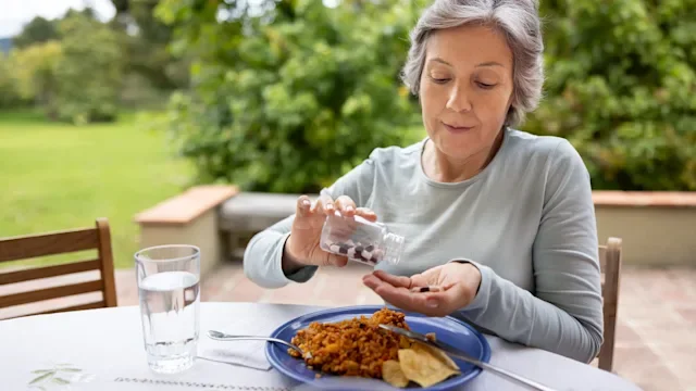 Health: Peptic ulcer disease: woman taking medicine with meal 1353083044