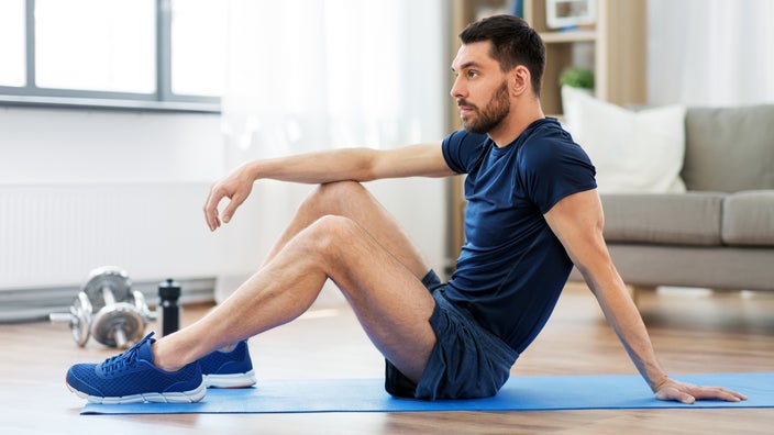 A man lies on an exercise mat. Kegel exercises, usually recommended for women to strengthen the pelvic floor, can provide benefits for men as well. 