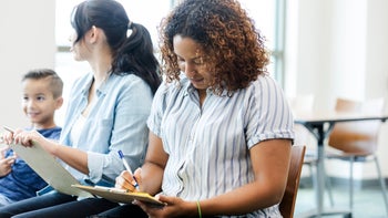 Finance: woman fills out paperwork 1742810540