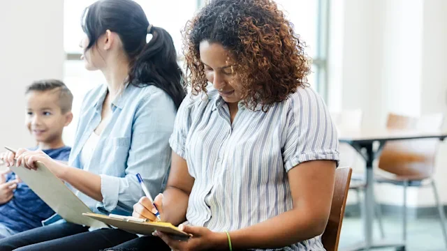 Finance: woman fills out paperwork 1742810540