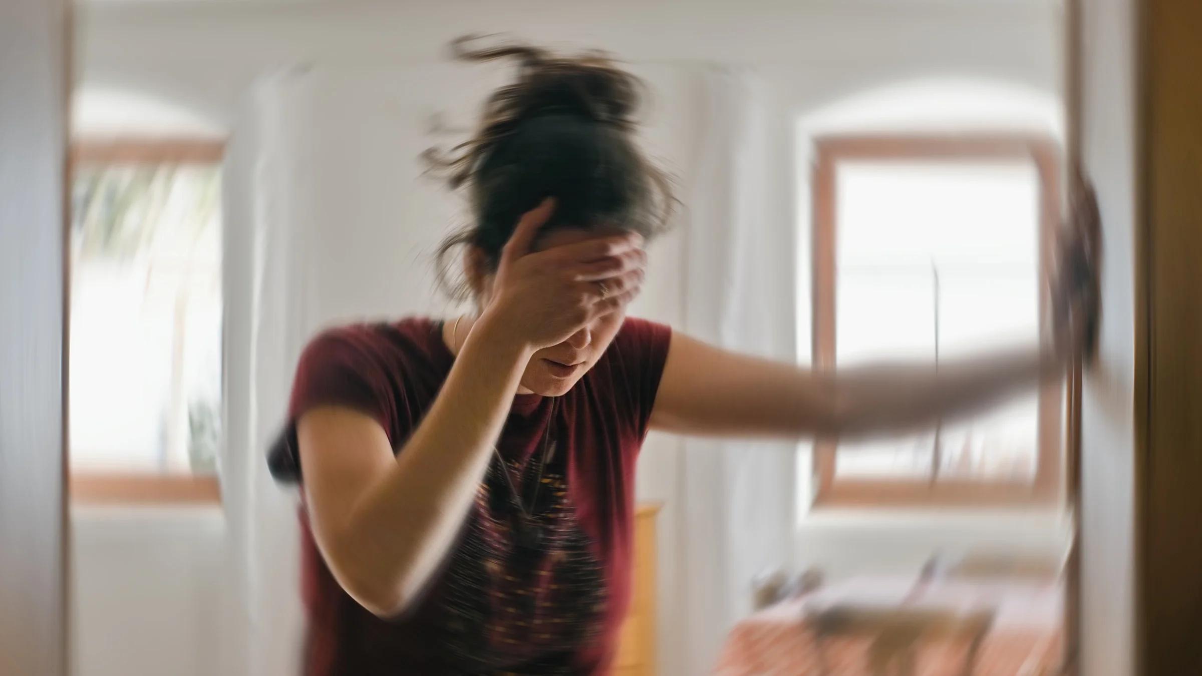A woman is suffering from dizziness in a blurred photo.