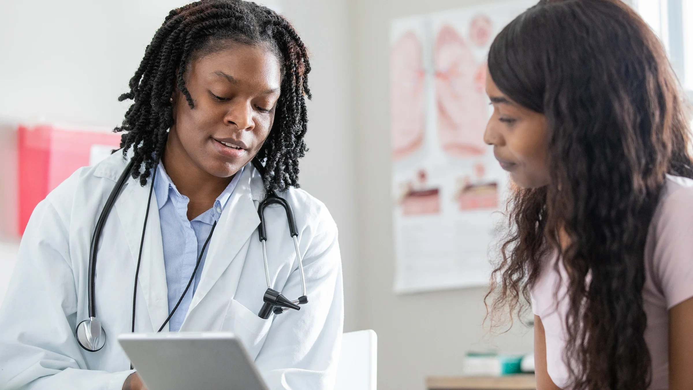 A healthcare professional uses a digital tablet while talking to a patient.
Courtney Hale/E+ via Getty Images