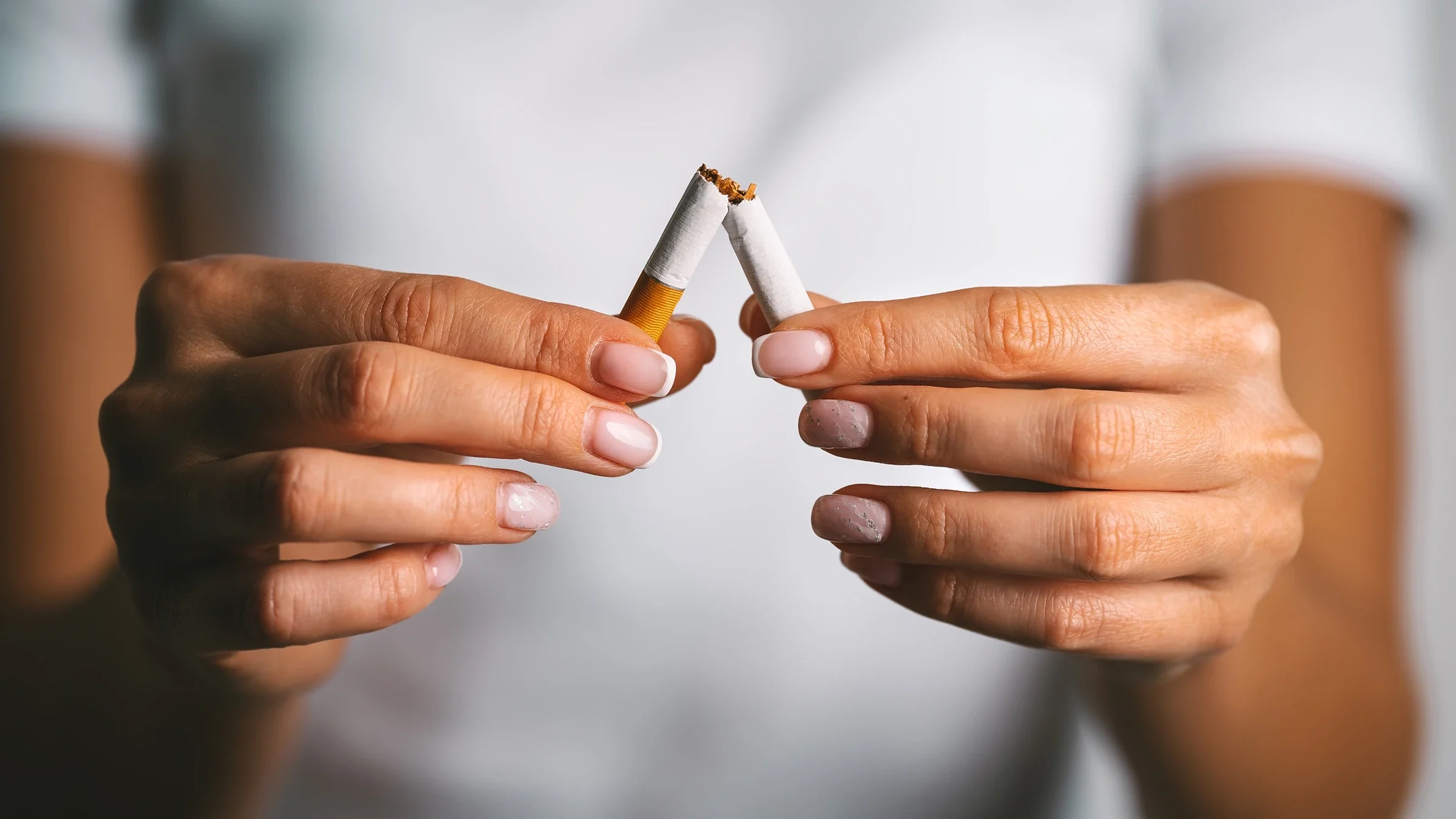 Close-up hands breaking cigarette in half