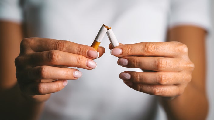 Close-up hands breaking cigarette in half