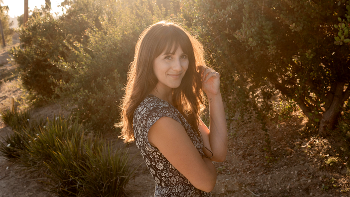 Carmel Samiri is pictured standing outdoors with the sun casting light in her hair.