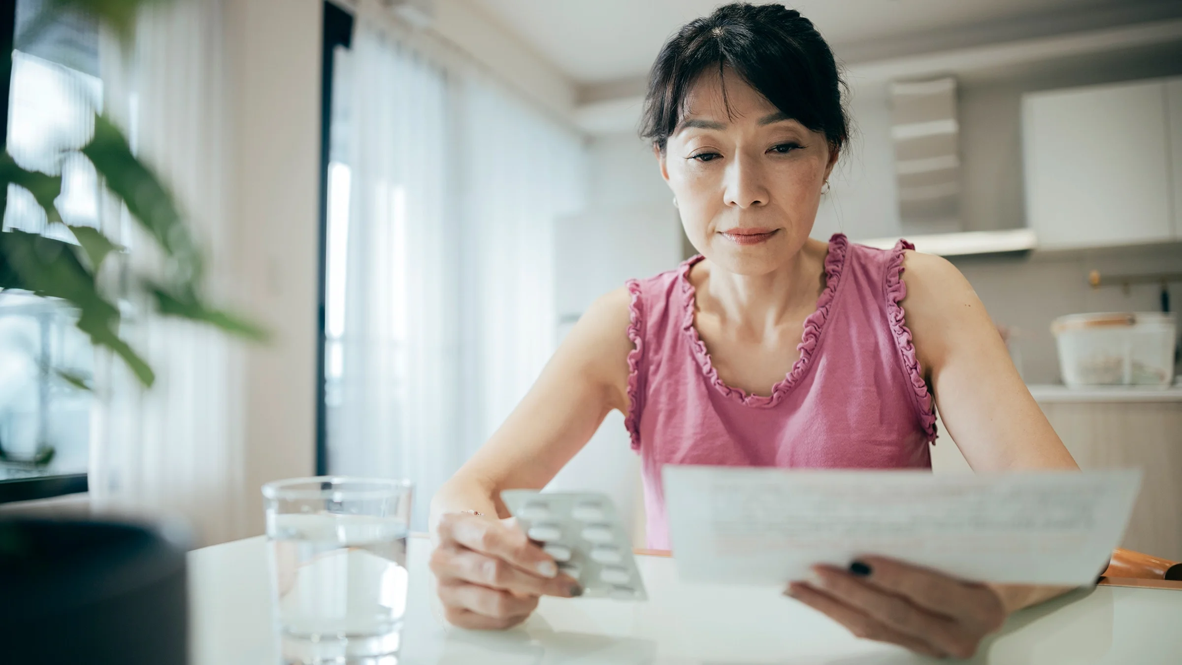 A woman reads the patient information leaflet for her medication.