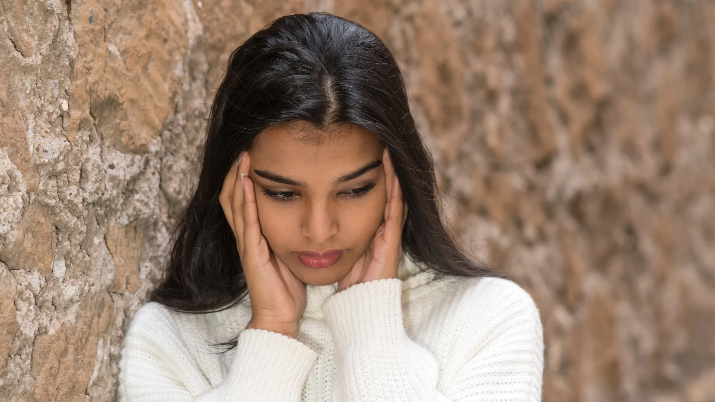 A person holding their temples in pain.