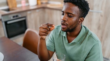 Adderall: man taking oral pill 2177981633