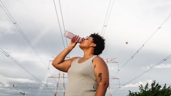 deep vein thrombosis: woman drinking water outdoors 1299829179