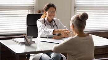 Health: Providers: doctor shaking patients hand across desk-1319103281
