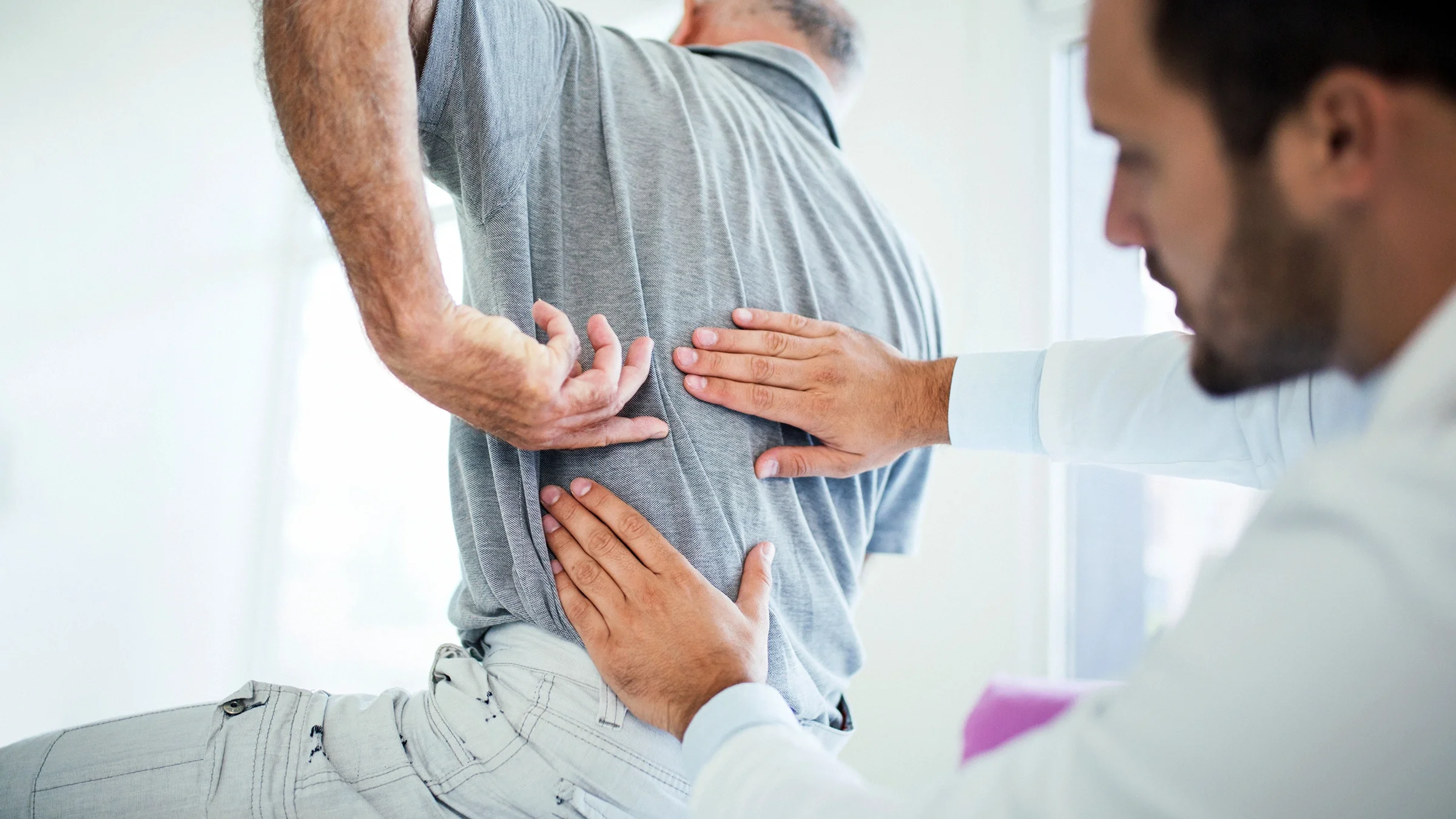 A healthcare provider conducts a kidney exam on his patient.