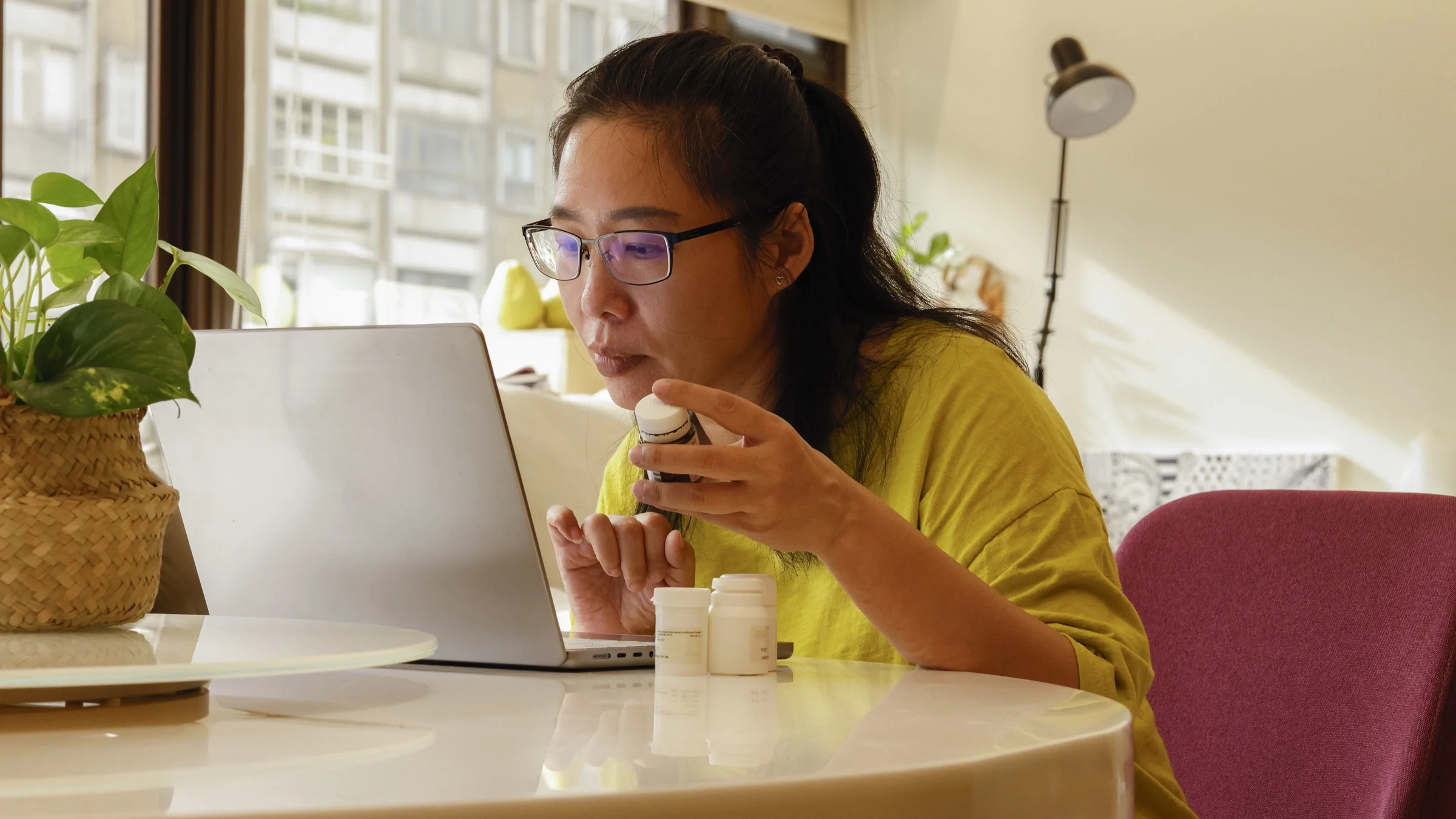 A person holding pill bottles in a telehealth call.